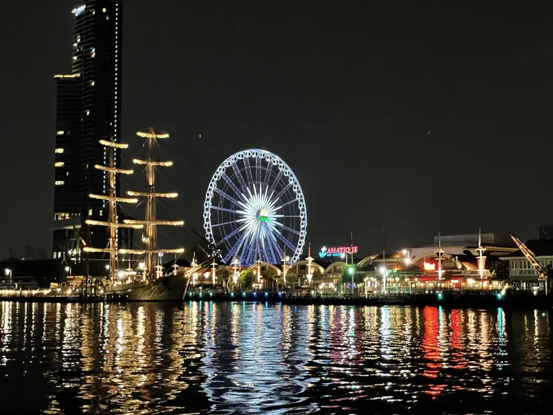 Vòng đu quay và khu chợ Asiatique rực sáng về đêm bên sông Chao Phraya, Bangkok.