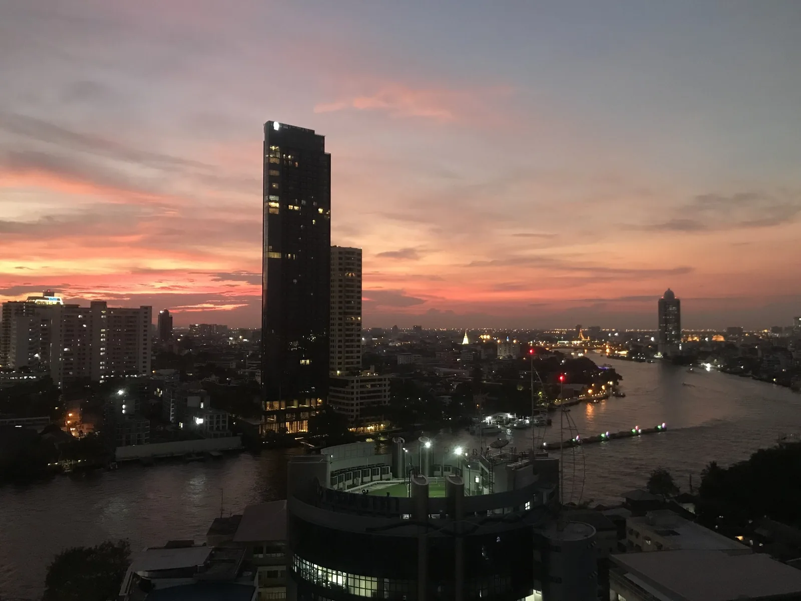 Hoàng hôn hồng rực rỡ phía trên sông Chao Phraya và các tòa cao tầng ở Bangkok.