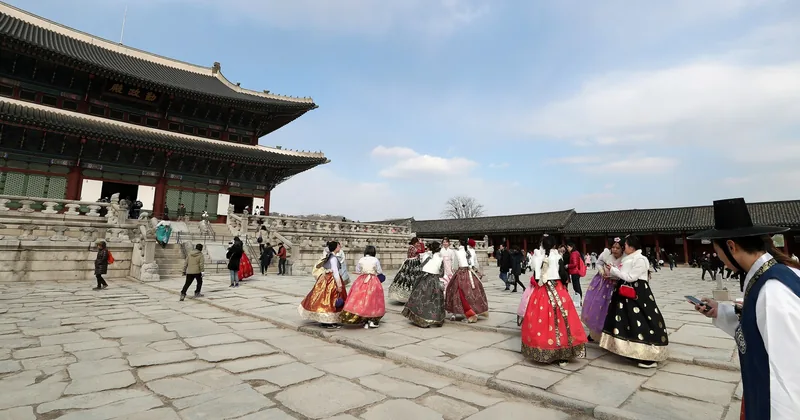 Du khách mặc hanbok sặc sỡ dạo bước trên sân đá của cung điện Gyeongbokgung ở Seoul.