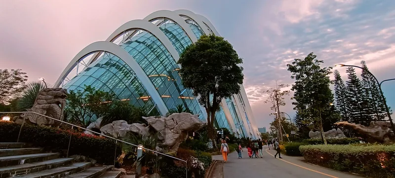 Mái vòm kính Cloud Forest vươn cao trên con đường vườn với du khách dạo bước lúc chiều tà ở Singapore.