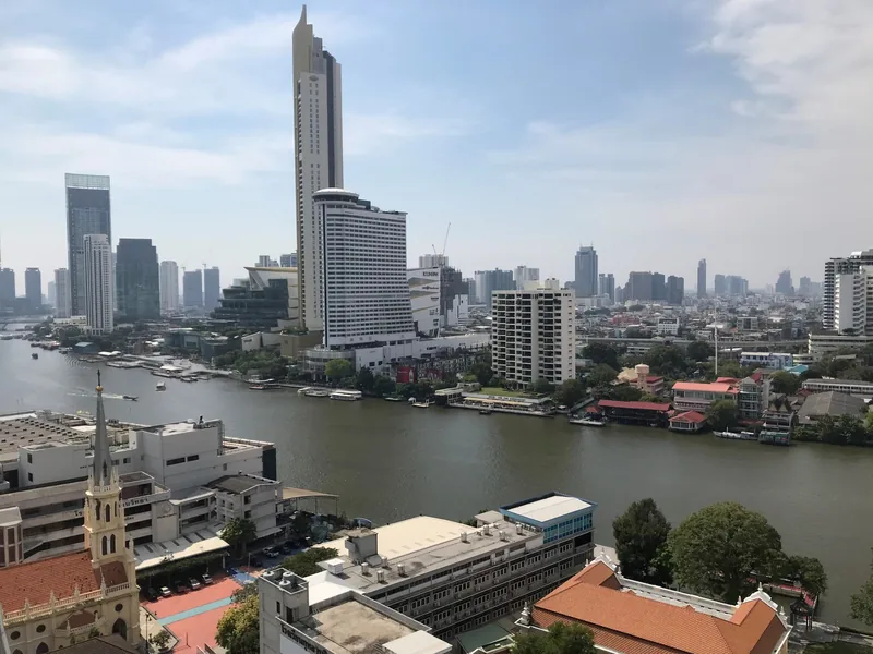 Toàn cảnh sông Chao Phraya uốn quanh Bangkok với các tòa cao tầng và khu dân cư ven sông nhìn từ trên cao.