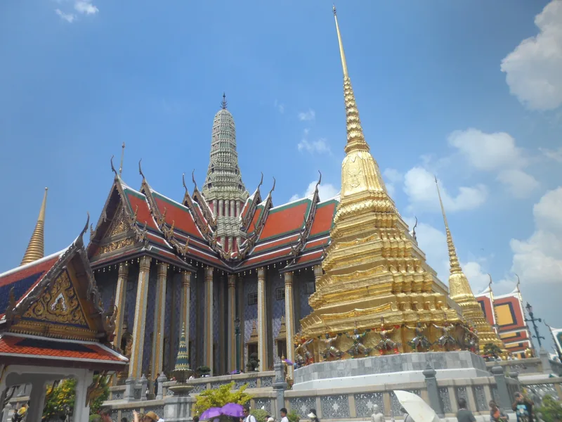 Tháp vàng và những mái nhà chạm khắc tinh xảo của Hoàng cung nổi bật trên nền trời xanh ở Bangkok.